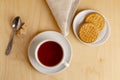 Cup of hot tea on a saucer, fresh biscuits, brown sugar and a cloth napkin. Royalty Free Stock Photo