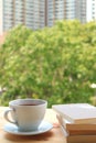 Cup of hot tea with stack of books on wooden table by the window, with Blurred Background Royalty Free Stock Photo