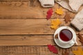 Cup of hot tea, sweater and autumn leaves on wooden table, flat lay. Space for text Royalty Free Stock Photo
