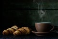 Cup of hot tea with two fresh croissants against dark background Royalty Free Stock Photo