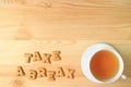 Cup of hot tea beside with the word TAKE A BREAK spelling with cookies biscuits on the wooden table Royalty Free Stock Photo