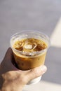 Cup of iced latte cappuccino coffee in hand on city street. Takeaway coffee drink Royalty Free Stock Photo