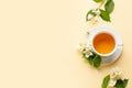 Cup of jasmine tea and flowers on color background Royalty Free Stock Photo