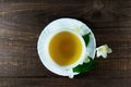 A cup of jasmine tea with jasmine flowers on a wooden background Royalty Free Stock Photo