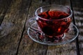 Cup karkade tea with bright red shade wooden background Royalty Free Stock Photo