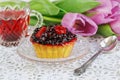 Cup of karkadeh red tea with berries cake and tulips Royalty Free Stock Photo