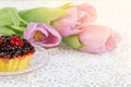 Cup of karkadeh red tea with berries cake and tulips Royalty Free Stock Photo