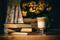 Cup of latte or cappuccino, old book and flowers.