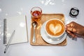 Cup of latte coffee in female hand on white plate.select focus. Royalty Free Stock Photo