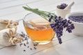 Cup of lavender tea and lavender flowers. Mortars of dry lavender and sachets on background. Alternative medicine