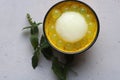 Cup of lemon sorbet flavored with mint and basil