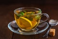 Cup of Lemon tea with lemon slices, cane sugar and mint on dark wooden background Royalty Free Stock Photo