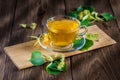 Cup of lime tea, standing on a wooden table, surrounded by fragrant linden flowers. Royalty Free Stock Photo