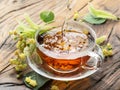 Cup of linden tea and lime flowers on the wooden table. Royalty Free Stock Photo