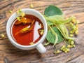 Cup of linden tea and lime flowers on the wooden table. Top view