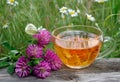 Cup of linden tea on a wooden table. white butterfly sitting on a cup of herbal tea. clover flowers and a cup of flower tea. herba