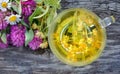 Cup of linden tea on a wooden table. white butterfly sitting on a cup of herbal tea. clover flowers and a cup of flower tea. herba Royalty Free Stock Photo