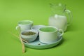 Cup of matcha latte and accessories for making on green background Royalty Free Stock Photo