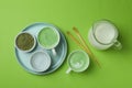 Cup of matcha latte and accessories for making on green background Royalty Free Stock Photo