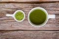 Cup of matcha tea and matcha green tea powder in tiny bowl on wooden table. Top view. Space for text. healthy food concept