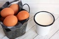 Cup of milk and brown Eggs in metal bucket