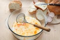 A cup of milk with eggs and pieces of white bread, the process of cooking fried toasts.