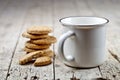 Cup of milk and stack of fresh baked oat cookies on rustic wooden table background.