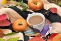 A cup of milk tea, sweet fresh buns and colorful autumn leaves on a striped warm picnic blanket Royalty Free Stock Photo