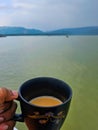 A cup of milk tea with the view of the hills of Meghalaya from the Tanguar Haor in Sylhet, Bangladesh