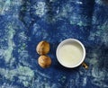 Cup of milk with walnuts  on blue grunge background Royalty Free Stock Photo