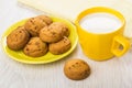 Cup of milk, yellow napkin, cookies on saucer on table Royalty Free Stock Photo