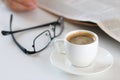 Cup of morning coffee on worktable with glasses and newspaper Royalty Free Stock Photo