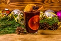 Cup of mulled wine with cinnamon, christmas decorations and fir tree branches on wooden table Royalty Free Stock Photo