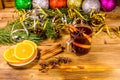 Cup of mulled wine with cinnamon, christmas decorations, sliced orange and fir tree branches on wooden table Royalty Free Stock Photo
