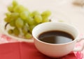Cup of natural coffee with grapes