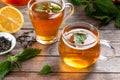 A cup of nettle tea on a table, with fresh stinging nettles in the background Royalty Free Stock Photo