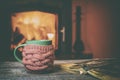 Cup, old book, glasses on vintage wood near fireplace Royalty Free Stock Photo