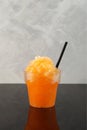 Disposable Plastic Cup of Orange Granizado or Orange Slushie drink with natural juice. Fruit shaved ice. Royalty Free Stock Photo