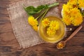 Cup ph healthy dandelion tea on vintage wooden background. Fresh herbs.