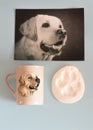 A dog labrador on the photo, a mug and a trace of his paw