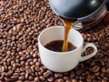 Cup and pot of coffee on coffee beans background Royalty Free Stock Photo