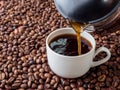 Cup and pot of coffee on coffee beans background Royalty Free Stock Photo