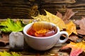 Cup pouring with water or tea with splashes on dark wooden background. Mug pouring with liquid with splashes and drops