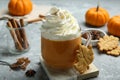 Cup of pumpkin spice latte with whipped cream, cookies and ingredients on light grey table, closeup Royalty Free Stock Photo