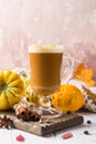 Cup of pumpkin spice latte with whipped cream on top and seasonal autumn spices, and fall decor. Traditional coffee drink Royalty Free Stock Photo