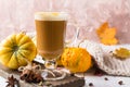 Cup of pumpkin spice latte with whipped cream on top and seasonal autumn spices, and fall decor. Traditional coffee drink for autu