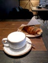 A cup of raff coffee and a croissant on the table