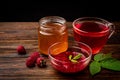 Cup of raspberry tea with raspberry jam and honey on dark wooden background Royalty Free Stock Photo