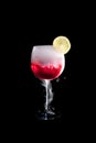 A cup of red cold cocktail with dry ice smoke and a lemon slice Royalty Free Stock Photo