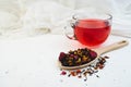 Cup of red hibiscus tea on white. Cozy background. Fruit and herbal dried leaves in wooden spoon Royalty Free Stock Photo